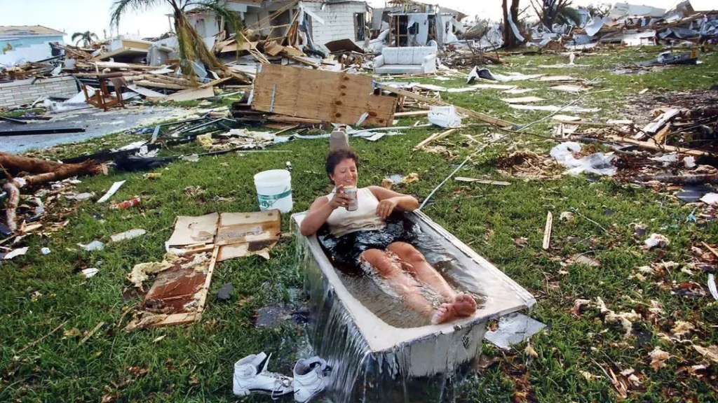 A woman enjoying a bath amidst catastrophic damage from Hurricane Andrew. South Florida. 1992.