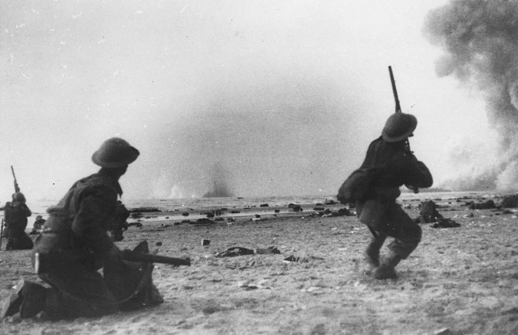 British soldiers fire their rifles at German aircraft flying overhead during the evacuation of Dunkirk, May-June 1940