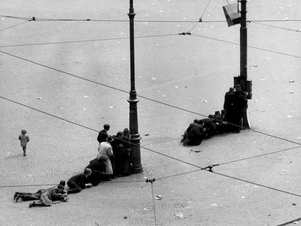People seeking shelter behind lamp-posts at Dam square Amsterdam after German troops opened fire at the celebrating masses (22 killed, 120 injured), 7 May 1945
