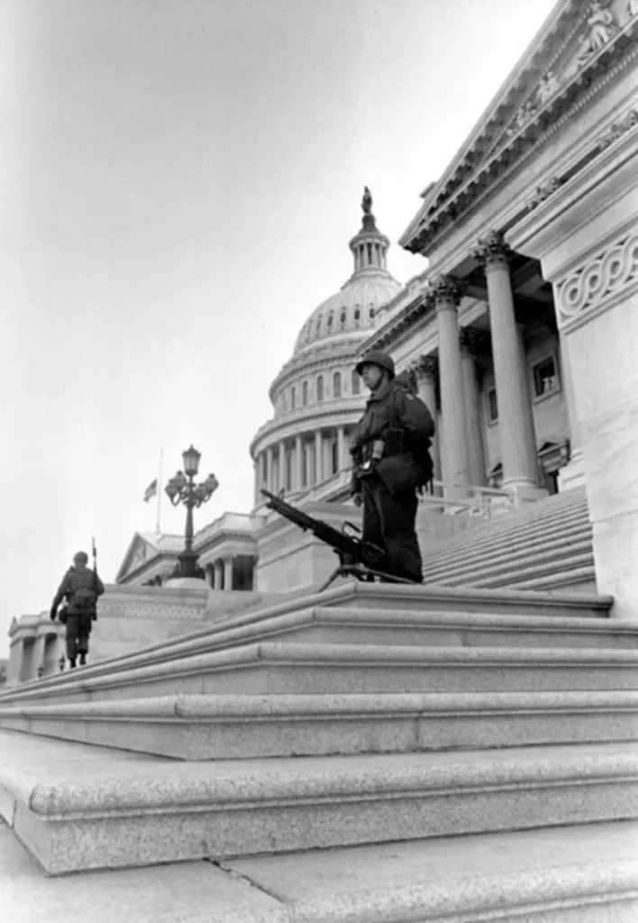 Soldier stands besides his M60 machine gun, which is mounted on the steps of the U.S. Capitol to deter rioters from entering the building during the Martin Luther King Jr. assassination riots in Washington D.C. (April 1968)