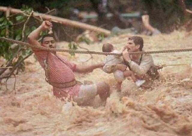 Two men and a child trying to survive Hurricane Hortense, Puerto Rico. September 9, 1996.